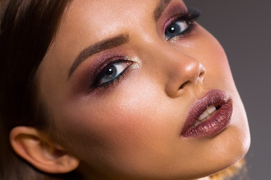 Dama sonriendo de frente con un maquillaje con aerógrafo, sobre los 5 beneficios del maquillaje con aerógrafo para lucir un look impecable y duradero