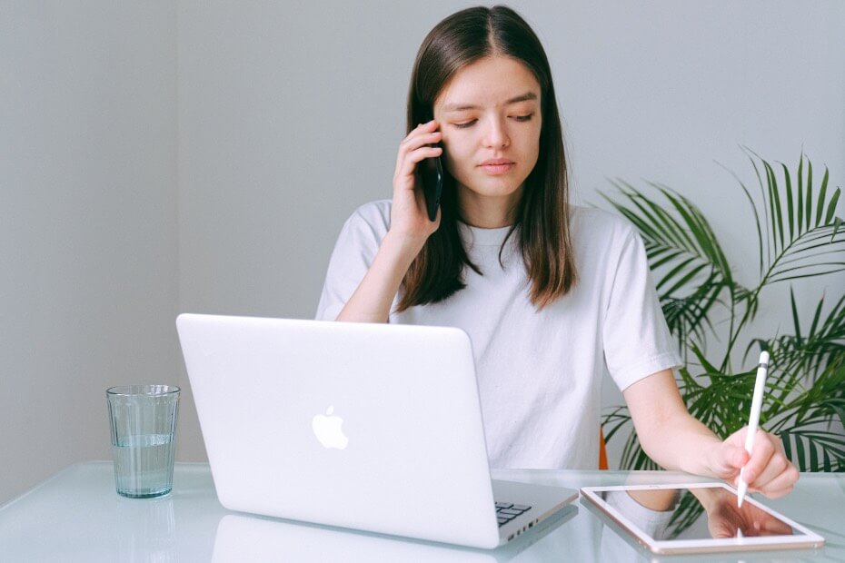 Mujer frente a laptop tomando una llamada en home office, mientras hidrata su piel, sobre adaptando tu rutina de belleza al home office