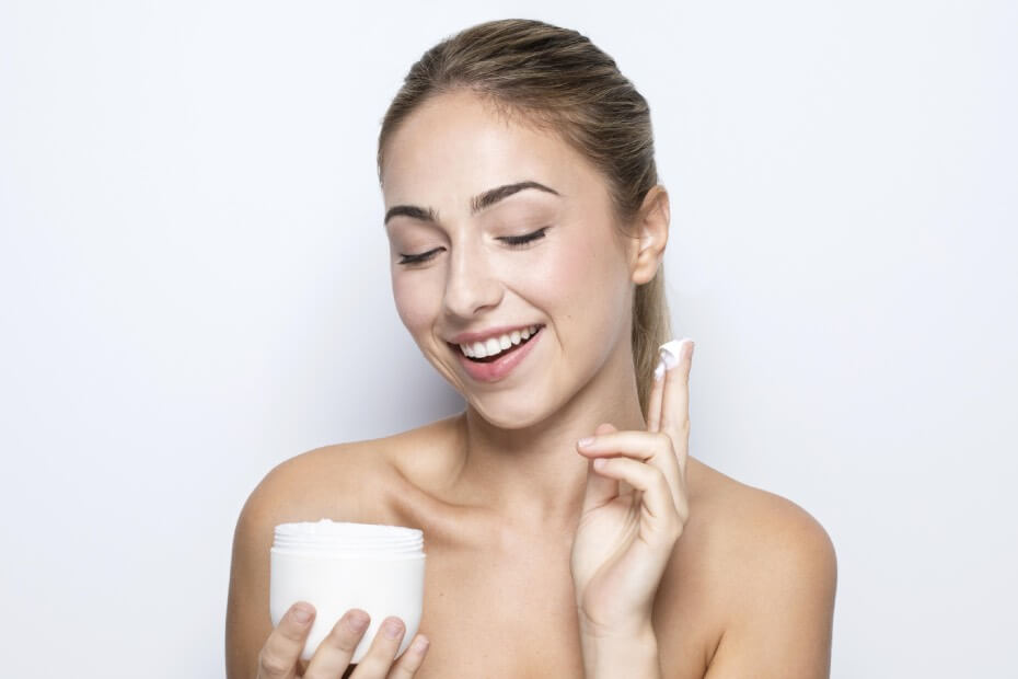 Mujer sonriendo y utilizando un bálsamo desmaquillante, recomendado por Foriu