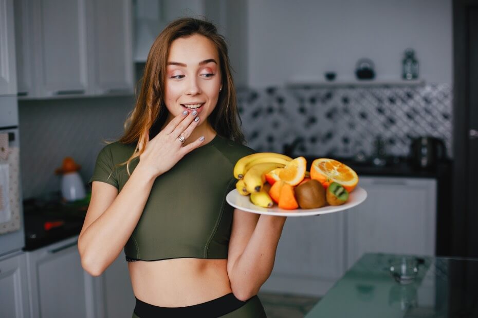 Mujer sosteniendo un plato con frutas para mantener una nutrición equilibrada antes del día de su boda