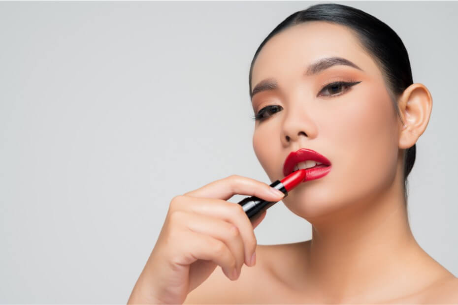 Mujer con maquillaje de noche posando con su labial rojo