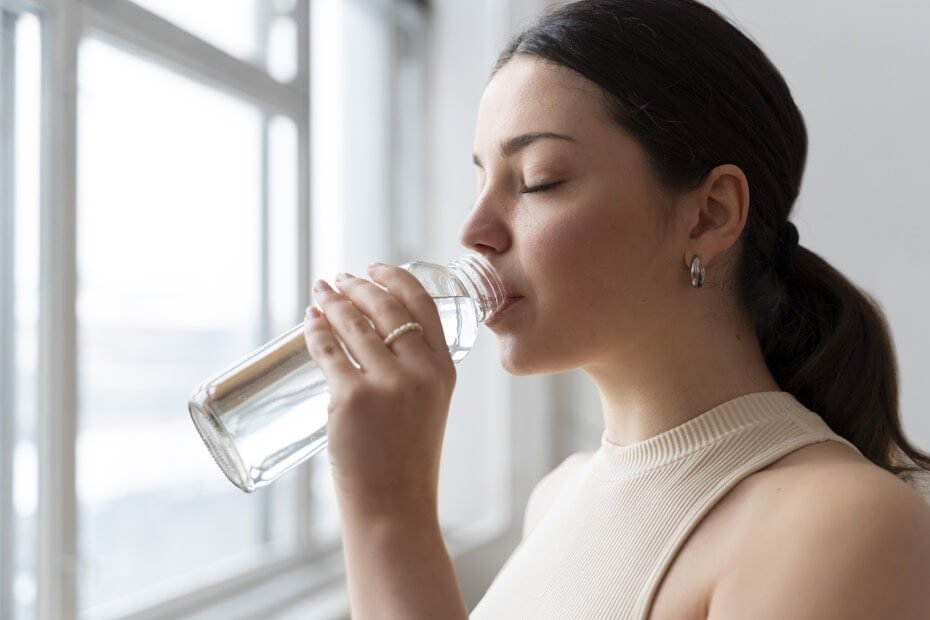 Mujer bebiendo mucha agua para evitar puntas abiertas siguiendo consejo de Foriu
