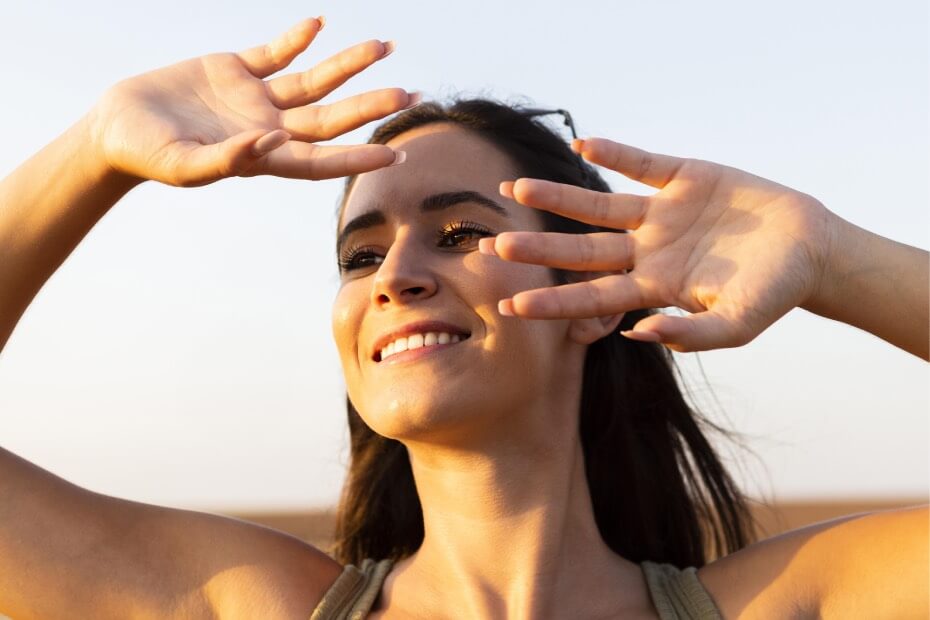 Mujer sonriente disfrutando de los rayos del sol porque siguió los tips de Foriu.