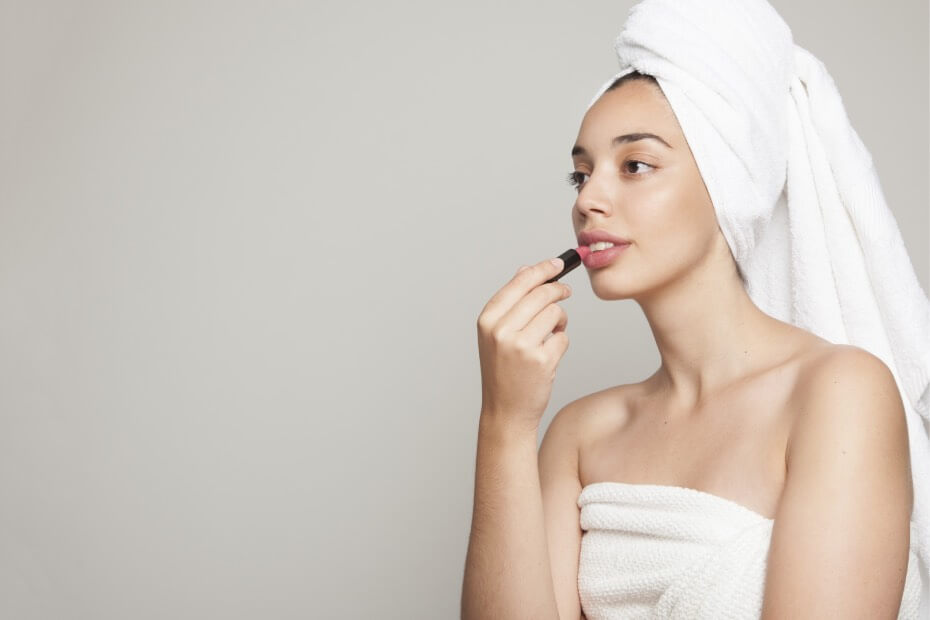 Mujer aplicándose bálsamo labial como lo sugirió foriu para tener sus labios hidratados.