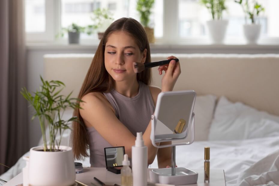 Joven aplicándose la cantidad de base perfecta de maquillaje ya que sigue los consejos de Foriu.