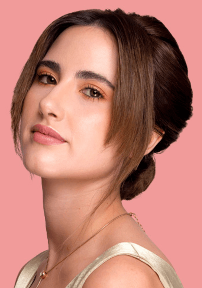 Chica posando de lado con su peinado recogido y maquillaje para eventos sociales en Medellín a domicilio