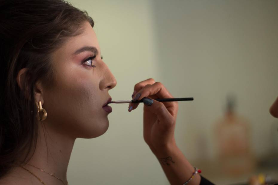 Mujer de lado siendo peinada y maquillada en Querétaro, sobre servicios de belleza a domicilio