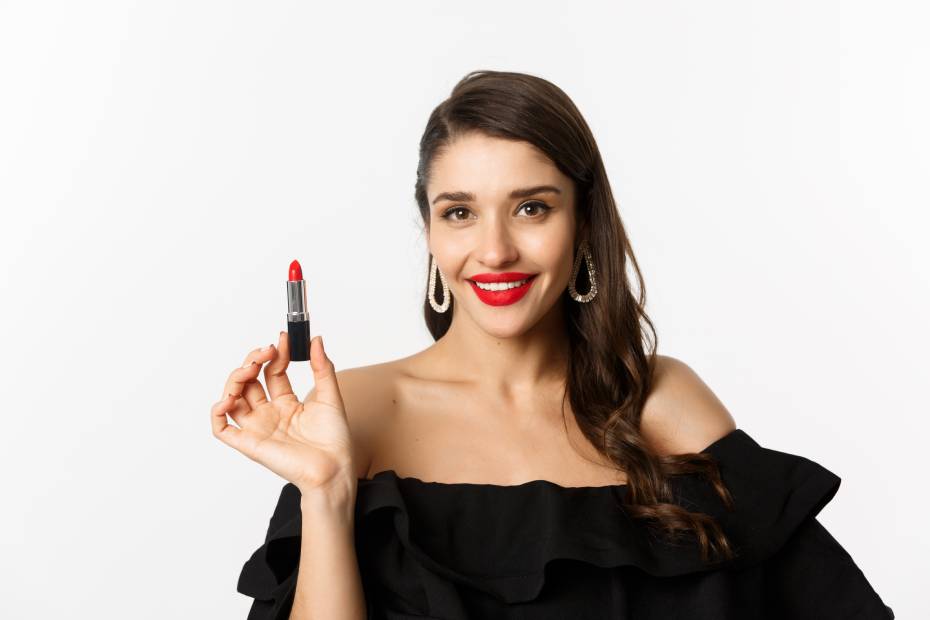 Mujer de frente sosteniendo un labial, sobre las mejores marcas de lipstick para lucir labios perfectos