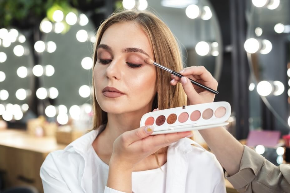 Mujer de frente con una paleta de colores siendo maquillada con maquillaje cruelty free, sobre las 6 mejores marcas de maquillaje cruelty free para una belleza consciente
