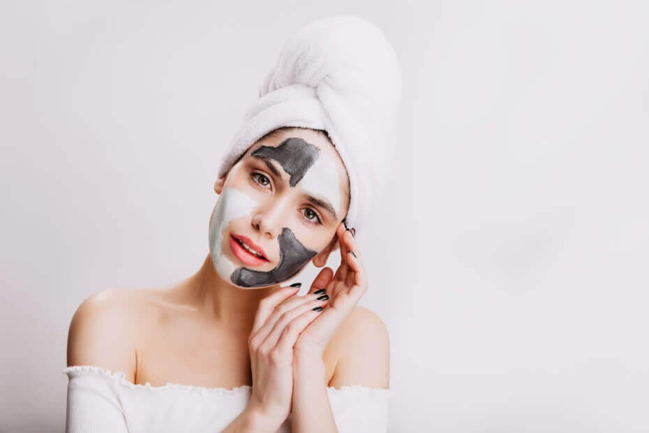 Mujer haciendo su mascarilla facial antes de acostarse y posando
