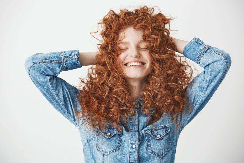 Mujer sonriente ya que cuida su cabello chino siguiendo las recomendaciones de foriu.
