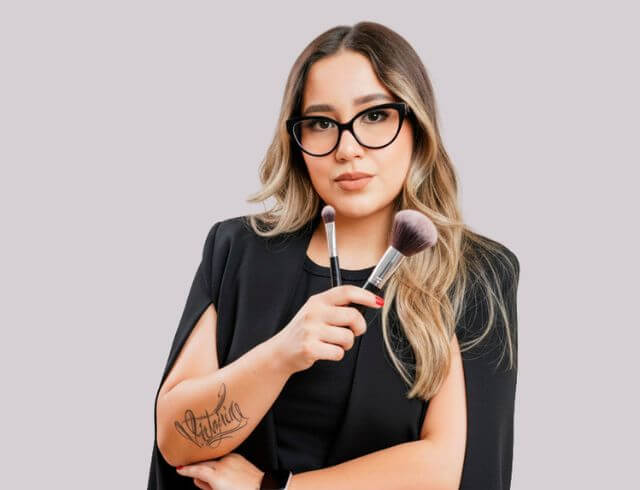 Coach maquillista profesional de Foriu, posando de frente con playera negra, especialista en peinado y maquillaje a domicilio para bodas y eventos sociales
