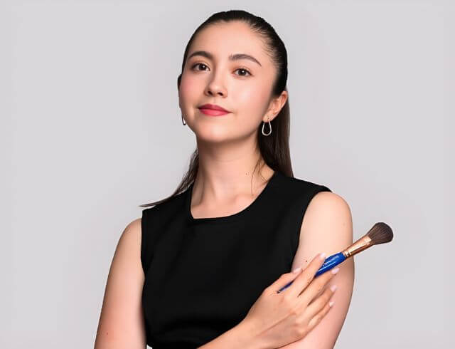 Coach maquillista profesional de Foriu, posando de frente con playera negra, especialista en peinado y maquillaje a domicilio para bodas y eventos sociales