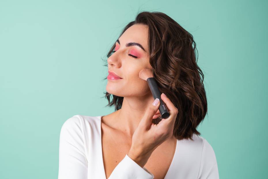 Mujer aplicándose la base de maquillaje, sobre tips para lograr un maquillaje profesional