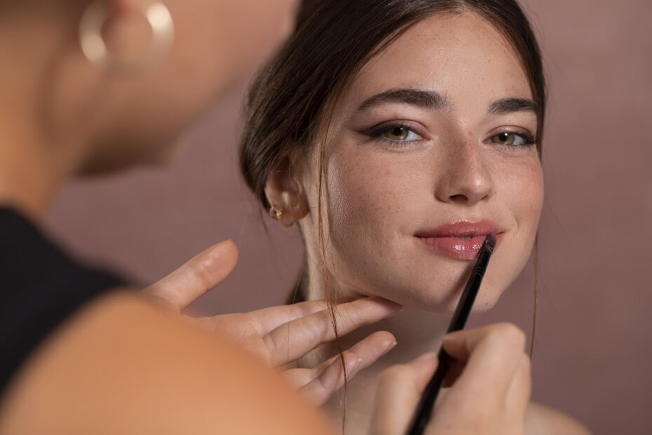 Mujer de frente siendo maquillada con colores pastel suaves, sobre tendencias de maquillaje que te harán brillar en tu graduación en 2023