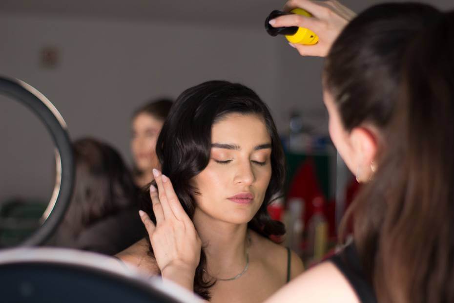 Mujer de frente siendo peinada y maquillada en puebla, sobre servicios de belleza a domicilio