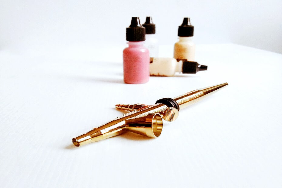 Un aerógrafo sobre una mesa, sobre los 5 beneficios del maquillaje con aerógrafo para lucir un look impecable y duradero