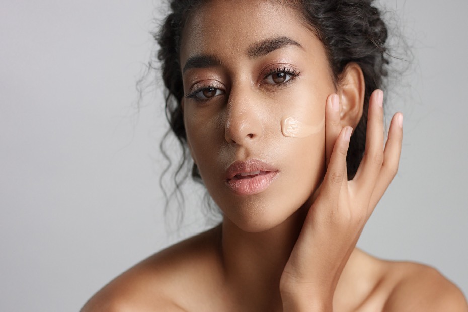 Mujer aplicándose BB Cream en su rostro, parte de su rutina de belleza con productos multifuncionales