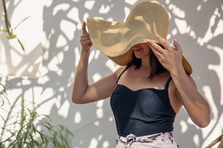 Mujer protegiendo su cabello del sol con sombrero para cuidar su cabello siguiendo consejo de Foriu