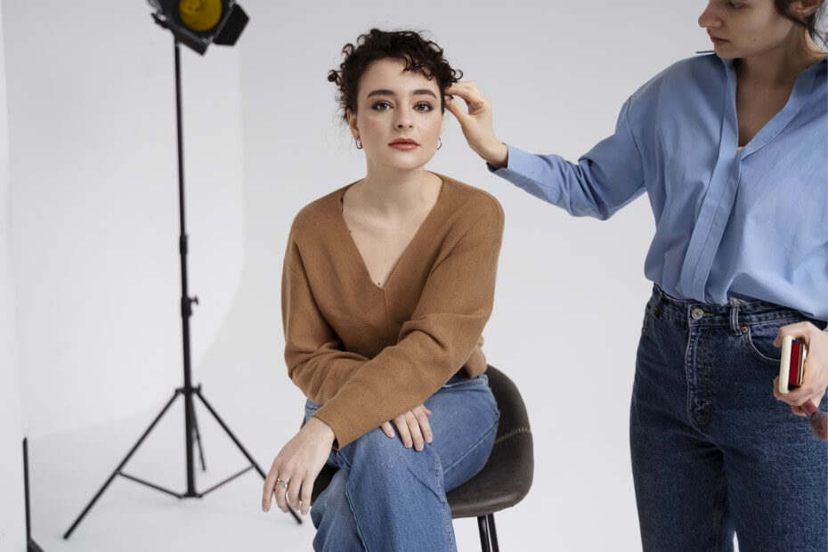 Coach de Foriu retocando a influencer en estudio fotográfico.